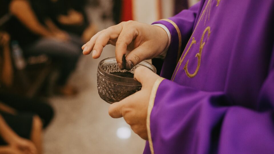 Priest distributing ashes at Mass